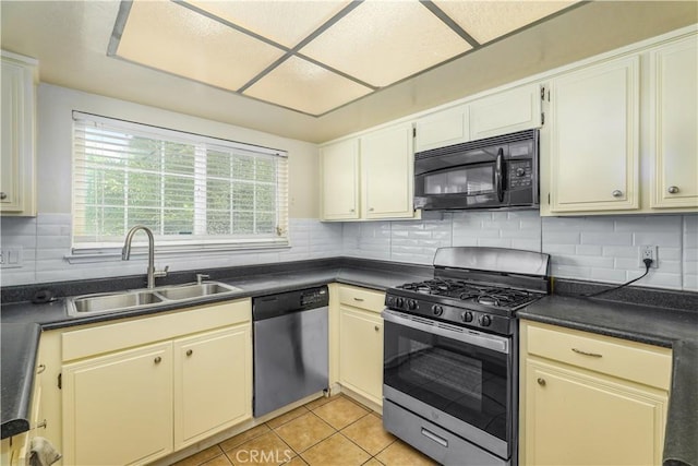 kitchen with backsplash, sink, light tile patterned flooring, and appliances with stainless steel finishes