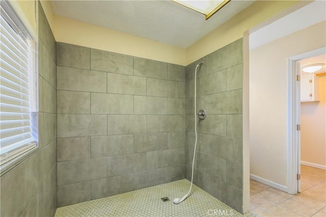 bathroom with a tile shower, a textured ceiling, and tile patterned floors