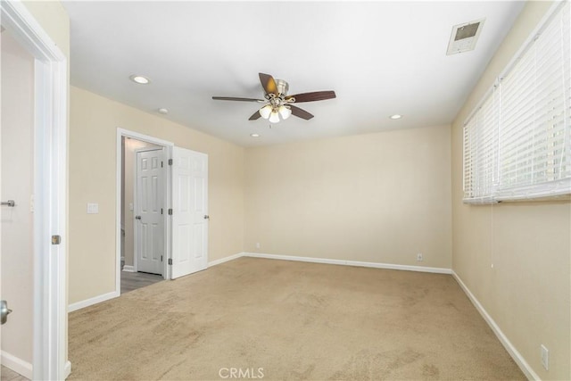 carpeted spare room featuring ceiling fan