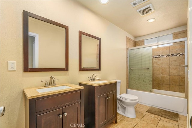 full bathroom featuring tile patterned flooring, vanity, toilet, and bath / shower combo with glass door