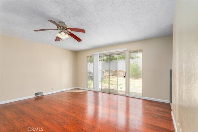 empty room featuring ceiling fan, dark hardwood / wood-style flooring, and a textured ceiling