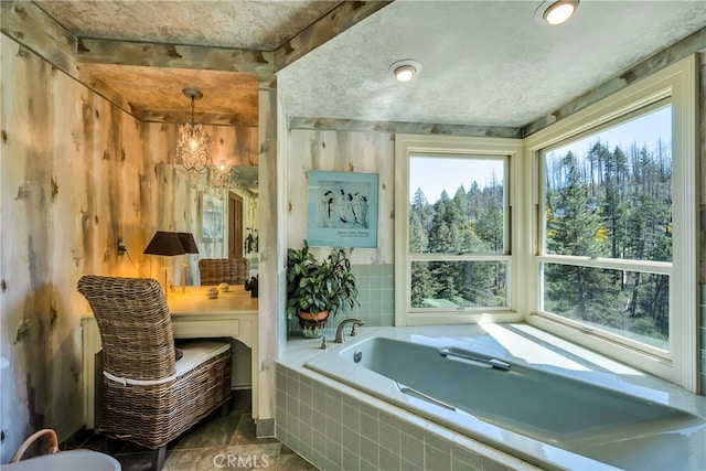 bathroom with tile floors, a notable chandelier, and tiled tub