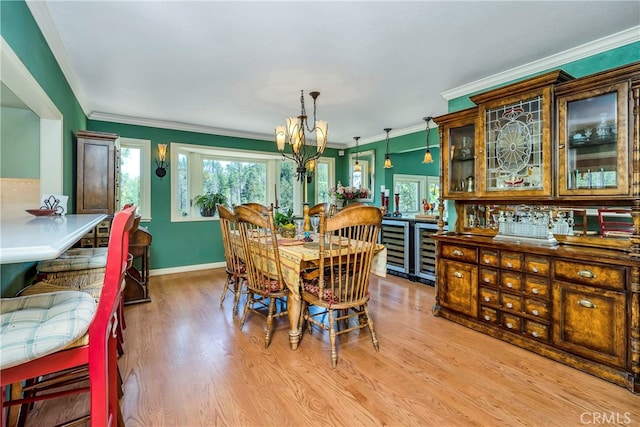 dining room with beverage cooler, ornamental molding, a healthy amount of sunlight, and light wood-type flooring