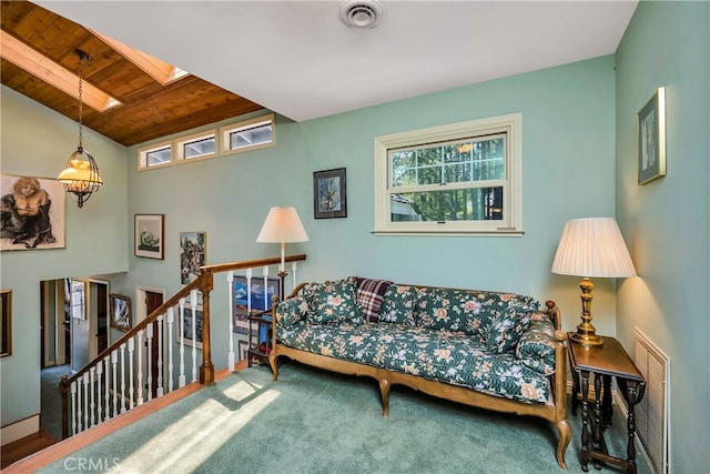 carpeted living room featuring wooden ceiling and a skylight