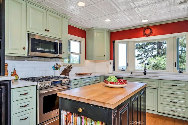 kitchen featuring light hardwood / wood-style flooring, tasteful backsplash, butcher block countertops, stainless steel appliances, and sink