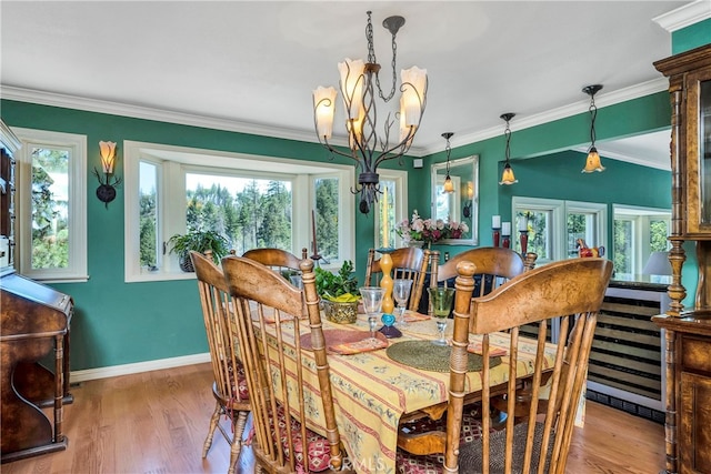 dining area with a notable chandelier, hardwood / wood-style floors, and ornamental molding