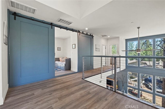 hall with a barn door and dark hardwood / wood-style flooring