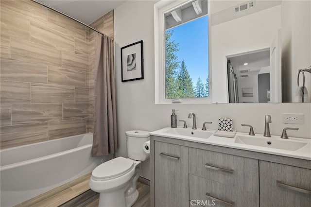 full bathroom with shower / bath combo, vanity, hardwood / wood-style flooring, and toilet