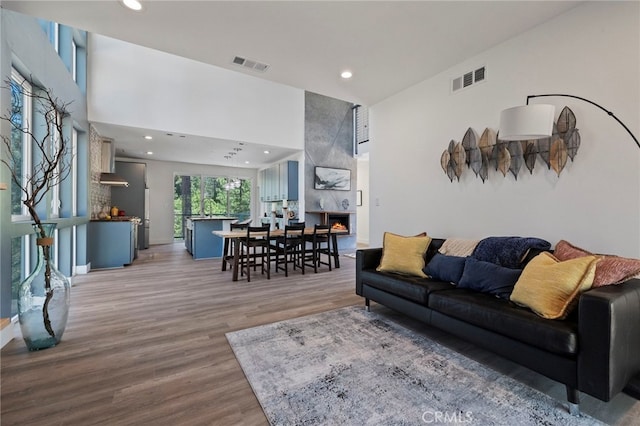 living room with light hardwood / wood-style floors, sink, and a high ceiling