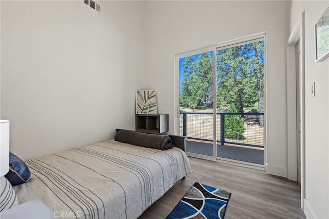 bedroom featuring access to exterior and hardwood / wood-style flooring