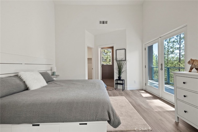 bedroom featuring access to exterior, french doors, and light hardwood / wood-style floors