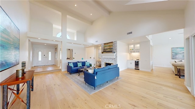 living room with high vaulted ceiling, beverage cooler, and beam ceiling