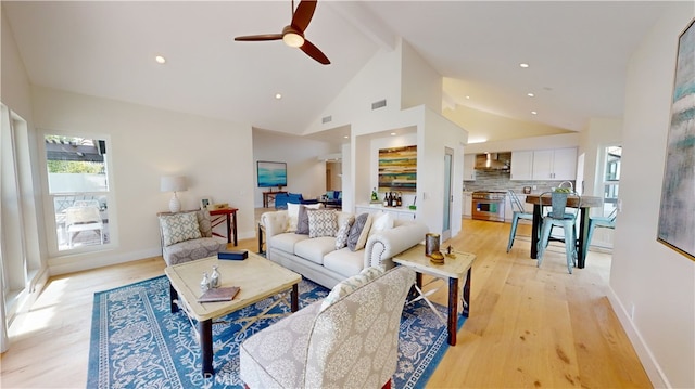 living room with high vaulted ceiling, beam ceiling, light hardwood / wood-style floors, and ceiling fan