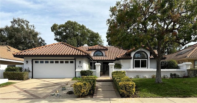 mediterranean / spanish-style house featuring a garage and a front lawn