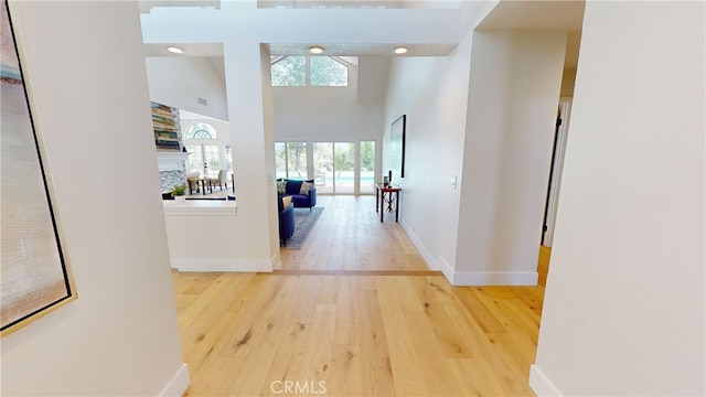 hallway with a towering ceiling and hardwood / wood-style flooring