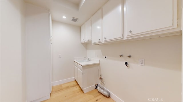 laundry room featuring sink, hookup for a washing machine, cabinets, hookup for an electric dryer, and light wood-type flooring