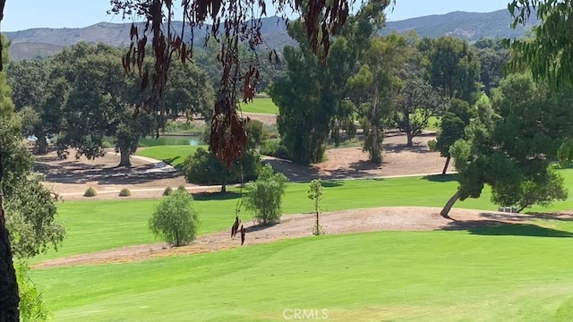 view of community featuring a lawn and a water and mountain view