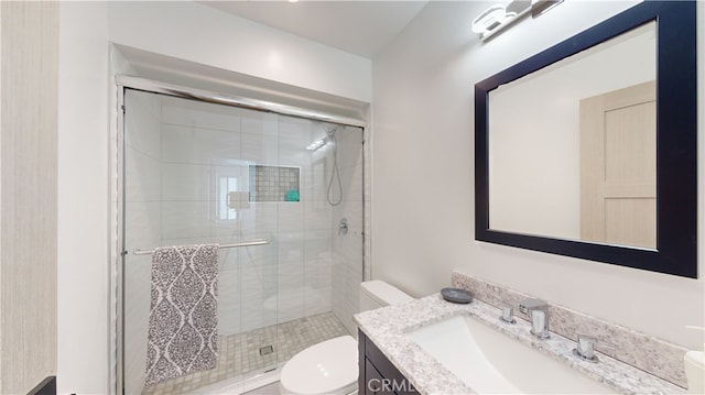 bathroom with vanity, a shower with shower door, and toilet