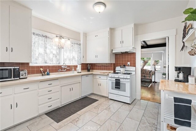 kitchen with sink, light hardwood / wood-style flooring, white appliances, decorative backsplash, and white cabinets