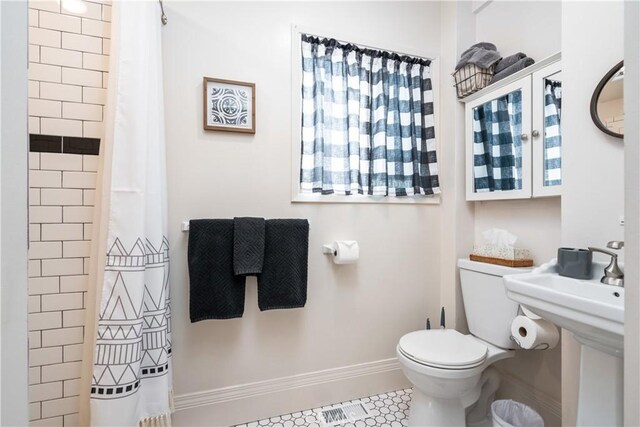 bathroom featuring tile patterned flooring, a shower with curtain, and toilet