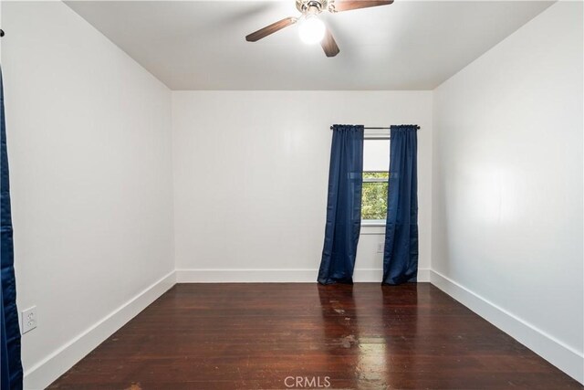 empty room featuring ceiling fan and dark hardwood / wood-style flooring