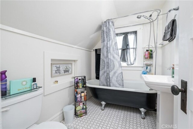 bathroom featuring lofted ceiling and toilet