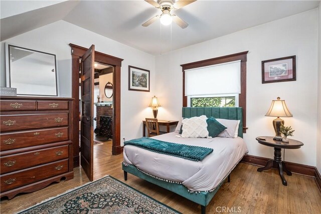 bedroom with light hardwood / wood-style floors, ceiling fan, and lofted ceiling