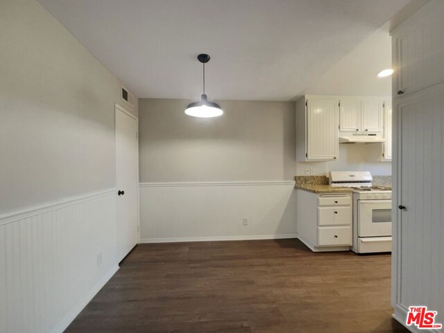 kitchen with light stone countertops, white gas stove, dark hardwood / wood-style flooring, decorative light fixtures, and white cabinets