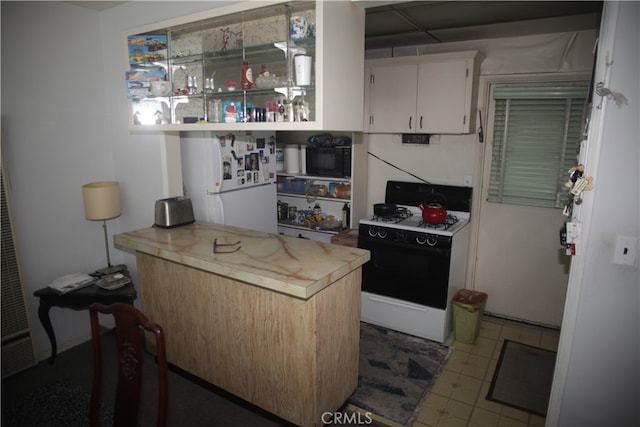 kitchen with tile flooring, white appliances, and white cabinetry