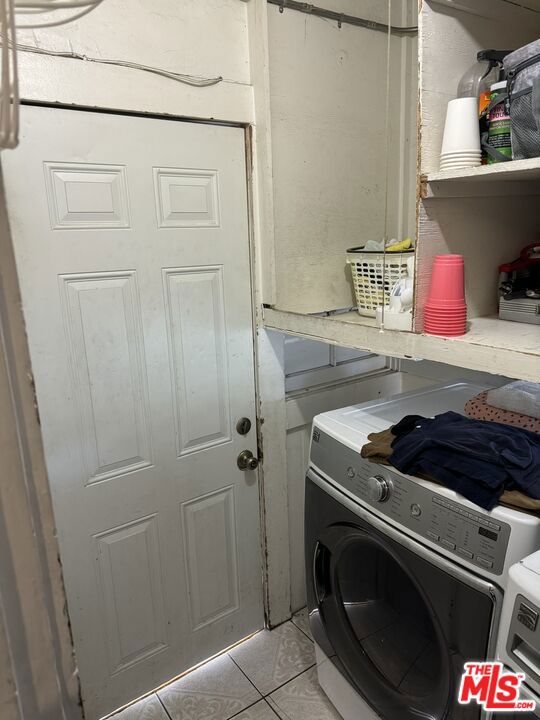 laundry area with washer and dryer and light tile patterned flooring