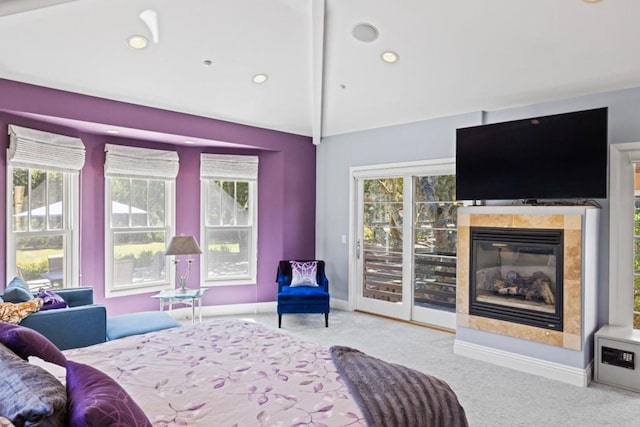 bedroom featuring lofted ceiling with beams, access to exterior, light carpet, and a tiled fireplace