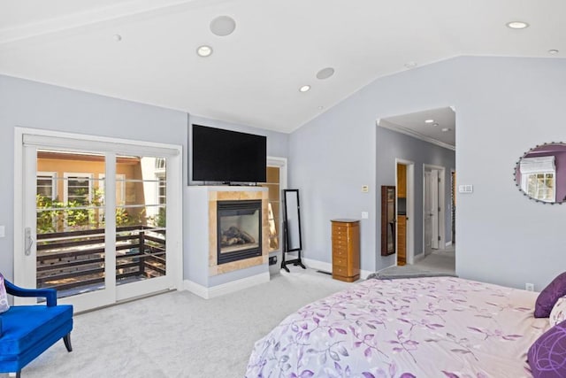 carpeted bedroom featuring access to exterior, lofted ceiling, and a tiled fireplace