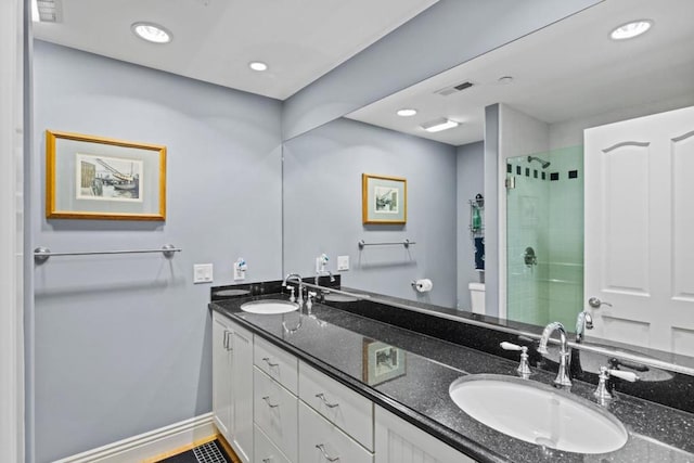 bathroom featuring vanity, a shower with shower door, and toilet