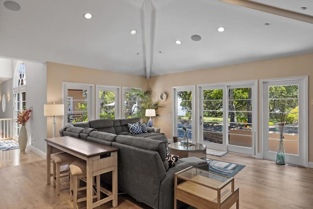 living room with vaulted ceiling with beams, light wood-type flooring, and a wealth of natural light