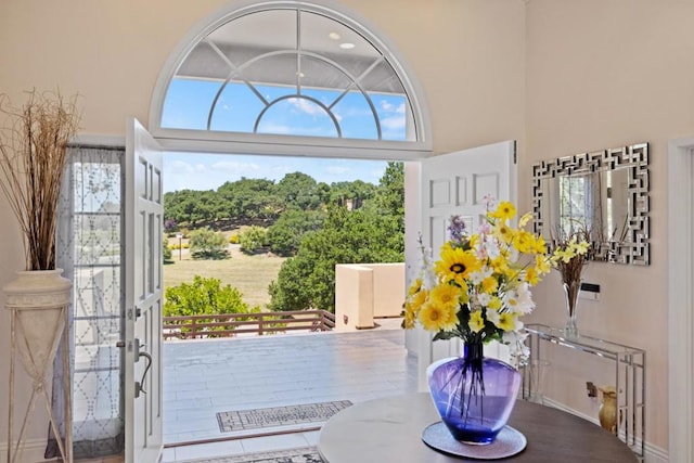 doorway to outside with a towering ceiling