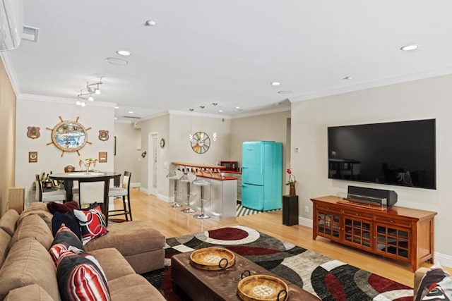 living room with light wood-type flooring and ornamental molding