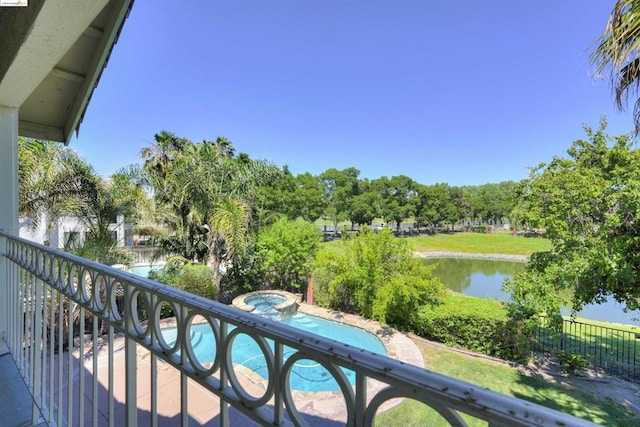 balcony featuring a water view and an in ground hot tub