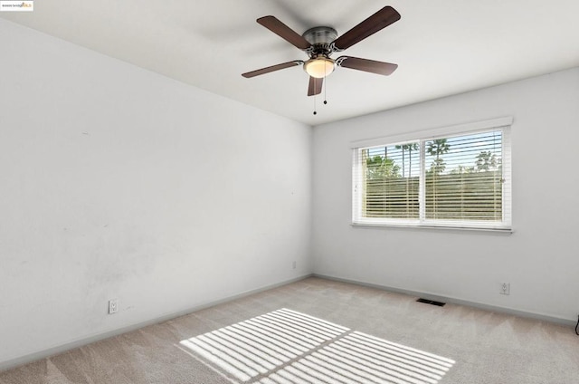 carpeted spare room with ceiling fan