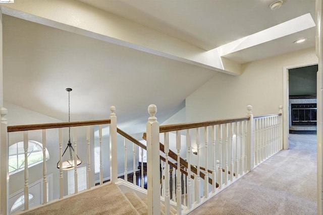 hall with an inviting chandelier, carpet, and lofted ceiling with beams