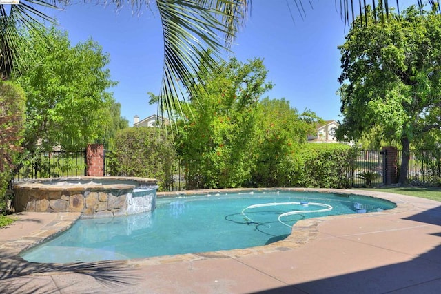 view of swimming pool with an in ground hot tub