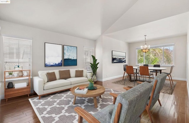 living room with lofted ceiling, wood-type flooring, and an inviting chandelier