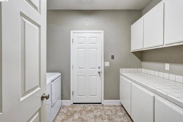 clothes washing area featuring cabinets and independent washer and dryer