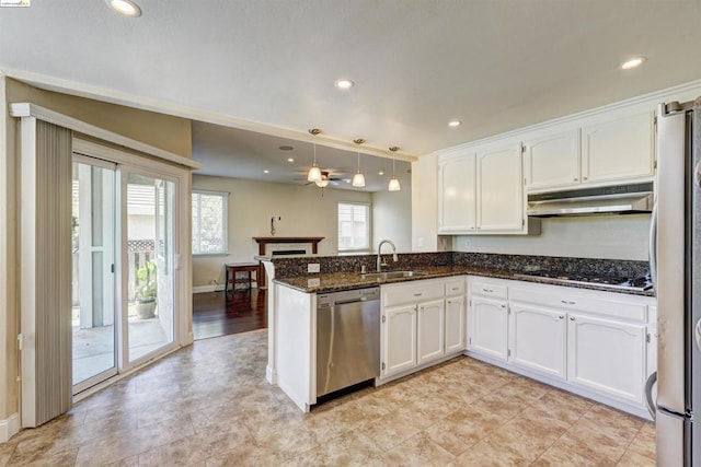 kitchen with kitchen peninsula, stainless steel appliances, decorative light fixtures, white cabinets, and sink