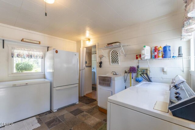 washroom with dark tile patterned floors and washer and dryer