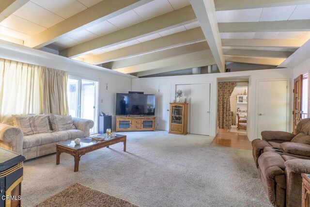 carpeted living room with vaulted ceiling with beams