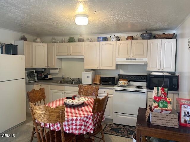 kitchen featuring sink, a textured ceiling, and white appliances