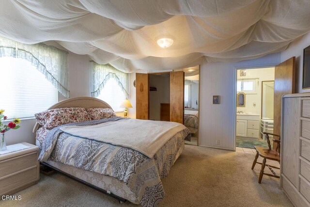 carpeted bedroom featuring ensuite bath