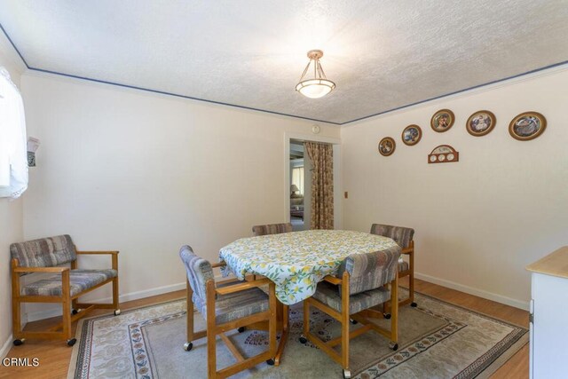 dining space featuring a textured ceiling and hardwood / wood-style floors