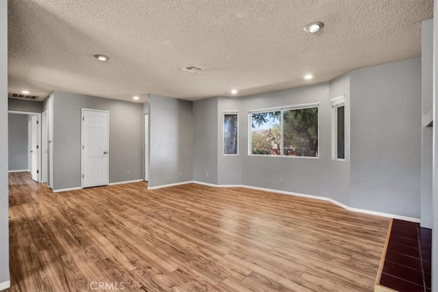 unfurnished room featuring a textured ceiling and hardwood / wood-style flooring