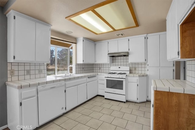 kitchen with white cabinets, tile counters, white appliances, and tasteful backsplash